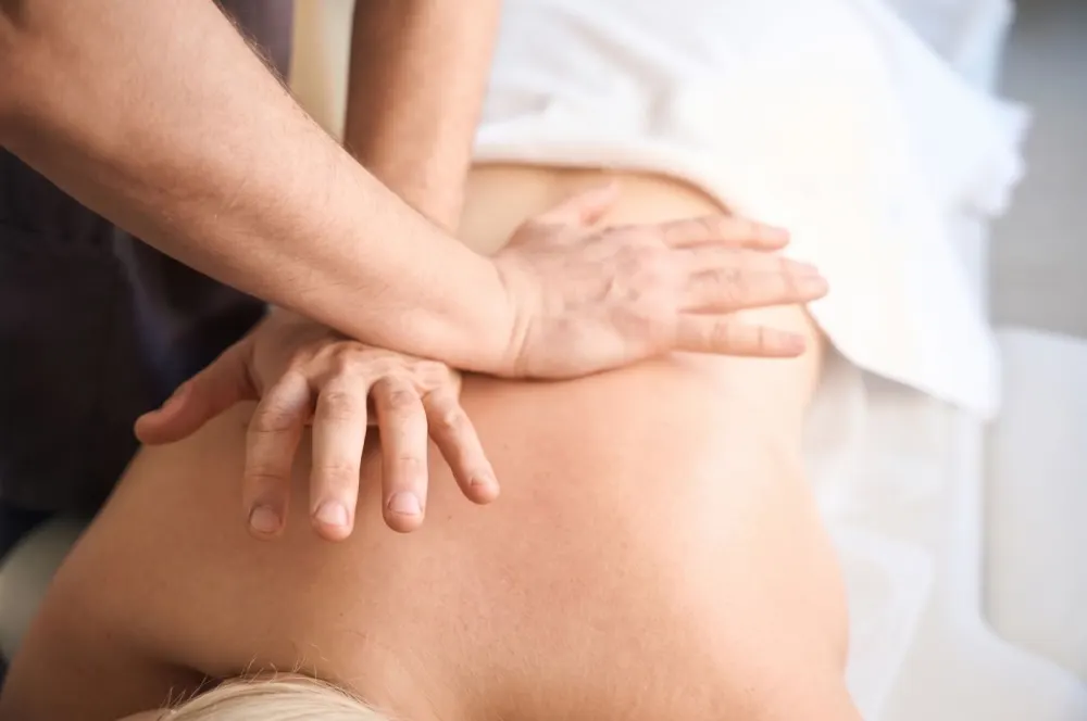 Sustained myofascial pressure applied along the lower back